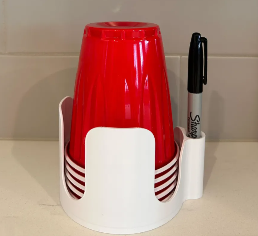 Party cup holder in White holding stacked red party cups and a marker